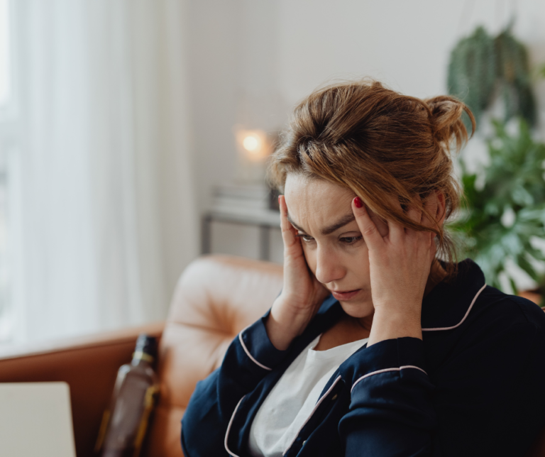 Woman seated leaning on one hand looking exhausted.